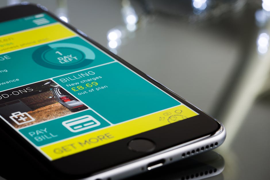 Close-up of a smartphone displaying a billing app interface on a reflective surface
